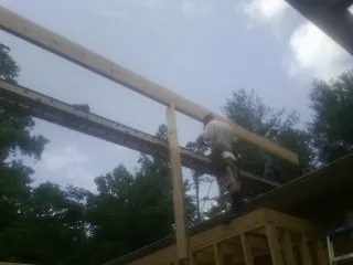 Carpenter setting a ridge beam over a new addition frame — Ice Dam Removal by Roofing Brothers in Smoketown
