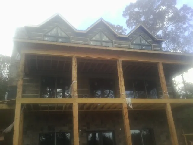 Dormers and porch framing on a large log home under construction — Roof Coating work by our crew in Smoketown